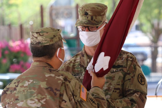 Col. Michael S. Oshiki, left, commander of WBAMC, passes the unit colors to Lt. Col. John P. Samuel, incoming commander of Fort Bliss Soldier Recovery Unit during a change of assumption and re-designation ceremony held at the SRU, July 21, 2020....