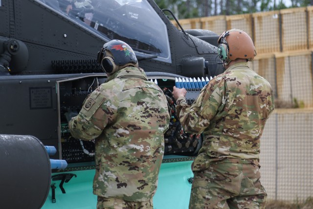 Sgt. Anthony Peck and Pvt. Treylon Mitchell, assigned to 1st Attack Reconnaissance Battalion, 82nd Combat Aviation Brigade, load ammunition onto a U.S. Army AH-64D Apache Longbow during an aerial gunnery range exercise at Fort Bragg, North Carolina, Jan. 27, 2020. The exercise allowed pilots to perform qualifications on the Apache’s weapons system and maintain mission readiness. (U.S. Army photo by Pfc. Joshua Cowden, 22nd Mobile Public Affairs Detachment)