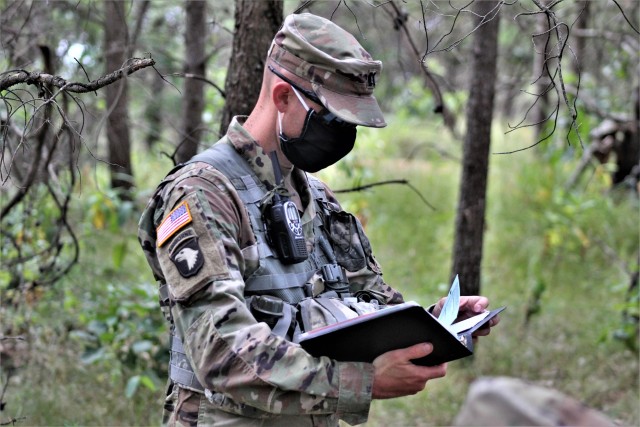 Capt. Terry Battison, a professor of military science at the Marquette University ROTC program, checks his notebook while leading field training Aug. 6, 2020, on a training area at Fort McCoy, Wis. Dozens of ROTC cadets from seven universities...