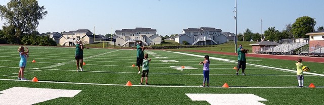 Youth Sports and Fitness staff Mallory Barnhouse, Jason Fullen and Patrick Shelton lead 5- and 6-year-old Fitness Camp participants Addilyn Banter, Chris Farrington, Ariana Alcantar and Liam Caffery in cool-down stretches at the end of the first...