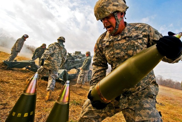 U.S. Army Pvt. Darrell Futrell lifts a 155mm round weighing about 100 pounds at Camp Atterbury Joint Maneuver Training Center in central Indiana. Engineers at Picatinny Arsenal are seeking to potentially extend the range of cannon artillery with new manufacturing methods that improve artillery shells, allowing them to withstand higher launch velocities and temperatures.