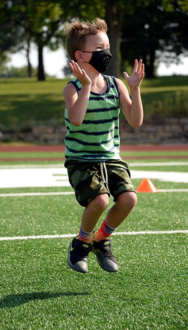 Five-year-old Chris Farrington leaps like a frog after crawling like a bear during Fitness Camp Aug. 24 at Normandy Field. Camp participants learned how to properly perform bodyweight and core exercises including modified push-ups and the plank,...