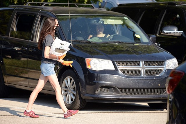 Katy Churchill, administrative coordinator for Protestant Women of the Chapel, delivers welcome packets, containing service and organization information and a scripture-of-the-month plaque, to PWOC members parked in front of Frontier Chapel for...