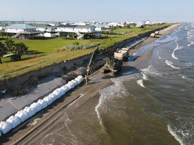 Members of the Louisiana National Guard&#39;s 843rd Engineer Company help local and state agencies reinforce the exposed burrito levee in Grand Isle before Tropical Storm Marco and Hurricane Laura. The hurricane was scheduled to make landfall Aug....