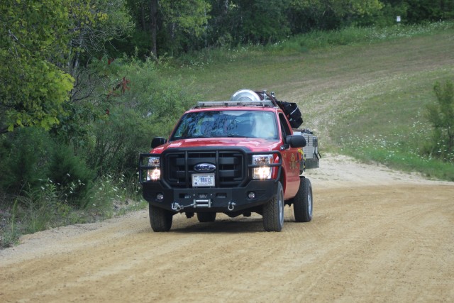 Firefighters with the Directorate of Emergency Services Fire Department take their brush/grass firefighting vehicle up a range road Aug. 6, 2020, on North Post to respond to a small range fire near the impact area at Fort McCoy, Wis. Like police,...