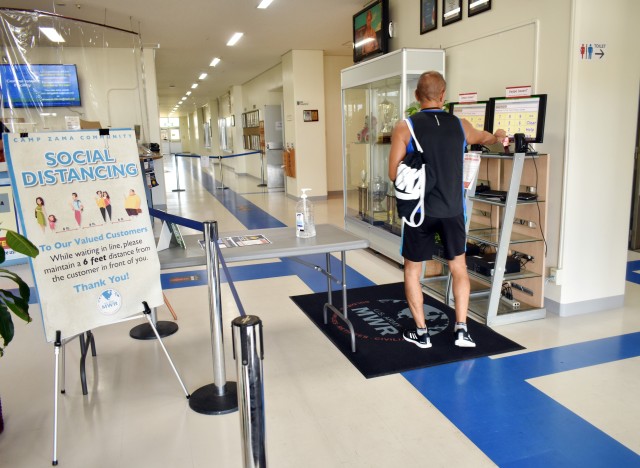 A social distancing sign and hand sanitizer greet patrons at the entrance to the Yano Fitness Center at Camp Zama, Japan, Aug. 27.