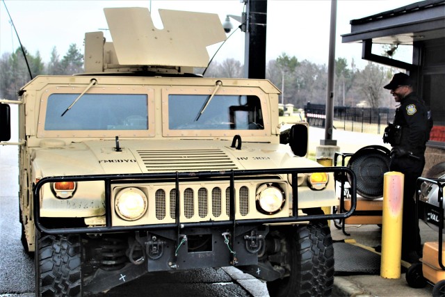 A police officer with the Directorate of Emergency Services Police Department checks identification cards April 3, 2020, at the Main Gate at Fort McCoy, Wis. At that time, it was still early in the installation’s response to the national...