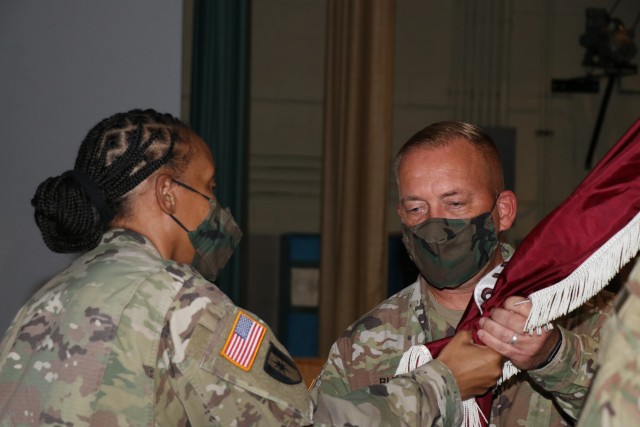 Sgt. Maj. Edmond B. Burnsed, Jr. receives the unit colors crom Lt. Col. Wendy Gray, Raymond W. Bliss Army Health Center (RWBAHC) Commander, symbolizing her charging him with the responsibility and authority that comes with his new position as the RWBAHC Sergeant Major.