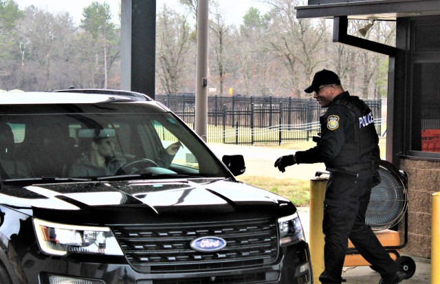 A police officer with the Directorate of Emergency Services Police Department checks identification cards April 3, 2020, at the Main Gate at Fort McCoy, Wis. At that time, it was still early in the installation’s response to the national...