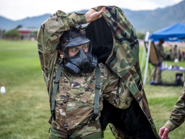 Pfc. Alberto Lara, a U.S. Army Reserve geospatial engineer with Headquarters and Headquarters Company, 11th Expeditionary Combat Aviation Brigade, dons a joint lightweight integrated suit technology coat during a round-robin event at Pershing...