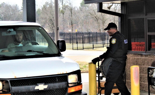 A police officer with the Directorate of Emergency Services Police Department checks identification cards April 3, 2020, at the Main Gate at Fort McCoy, Wis. At that time, it was still early in the installation’s response to the national...
