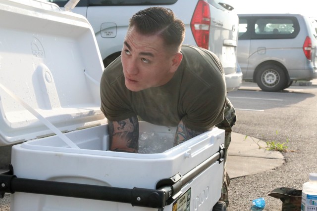 Sgt. 1st Class James Smith puts his arms in an ice bath to cool off after a 12-mile ruck during the United States Army Pacific Command Best Warrior Competition, Aug. 24, 2020, Camp Humphreys, Republic of Korea. This year, due to COVID-19, the competition takes place across the Indo-Pacific with competitors conducting events at their home station. (U.S. Army photo by Spc. Hayden Hallman, 20th Public Affairs Detachment)