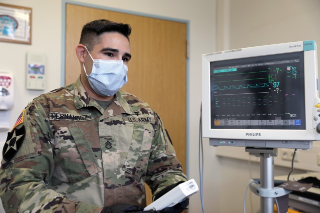 Staff Sgt. Michael Hernandez, the noncommissioned officer in charge of the respiratory department at Landstuhl Regional Medical Center, monitors a patient during a high altitude simulation test.
