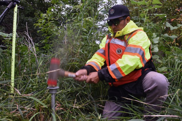Eduardo Torrens, St. Paul District civil engineer, uses a hammer to drive a survey monument into the ground along the Red River of the North, near Georgetown, Minnesota, Aug. 12. The Corps of Engineers, St. Paul District, in partnership with the Rock Island and Omaha districts and the FM Diversion Authority, are placing monuments to get a better understanding of the environment within the region and to monitor for any potential impacts related to the construction and/or operation of the Fargo – Moorhead Metro Diversion Flood Risk Management Project.