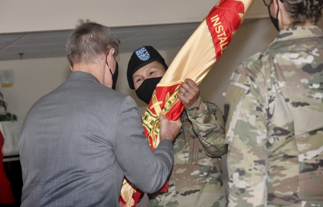 Col. Karin L. Watson, incoming commander, U.S. Army Garrison, accepts the colors from Vincent E. Grewatz, director, Installation Management Command-Training, during a change of command ceremony Aug. 7 at the Lee Club. Watson replaced Col. Hollie...