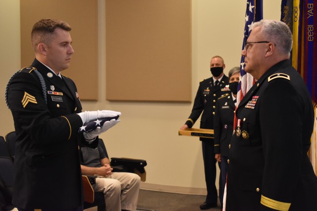 Sgt. Matthew Pleczkowski presents the flag of the United States to his father Chaplain (Brig. Gen.) Robert F. Pleczkowski during the retirement ceremony at The Heart and Home of the Army Chaplaincy at Fort Jackson on August 31. (Photo by Mr. Mel...