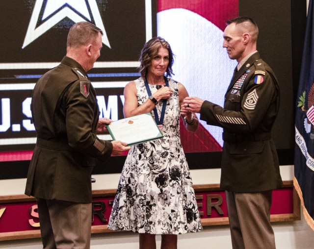 Anne E. Guden, wife of Command Sgt. Maj. Timothy A. Guden (Ret.), previous command sergeant major, U.S. Army Training and Doctrine Command, receives a certificate of appreciation from Gen. Paul E. Funk II, commanding general TRADOC, at Command...