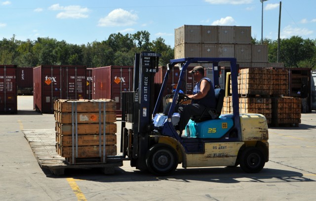Ammo boxes being moved from transport pallet to placement in container on BGAD&#39;s primary out-loading platform.