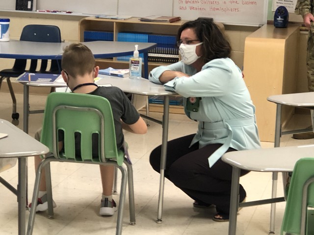 Christy Huddleston, Department of Defense Education Activity Americas Southeast District superintendent (left), talks with an Andre Lucas Elementary School student, Aug. 28, about his experiences during the first week of school. Huddleston visited...