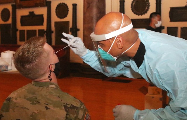 Maj. Tim McGee, an assistant professor in the Electrical Engineering and Computer Science department, places a swab into the nose of a cadet during the real-time reverse transcription polymerase chain reaction (rRT-PCR) test Aug. 26 at Cullum Hall.