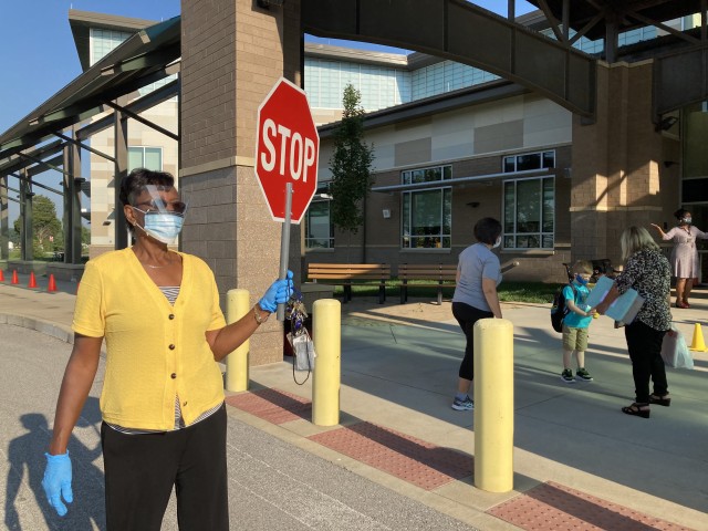 Fort Campbell, Ky.., Barkley Elementary School guidance counselor Teresa Moss directs parents dropping off students Aug. 24 for the first day of school to enforce social distancing guidelines. She said she also was there to help children with any anxiety they might have.