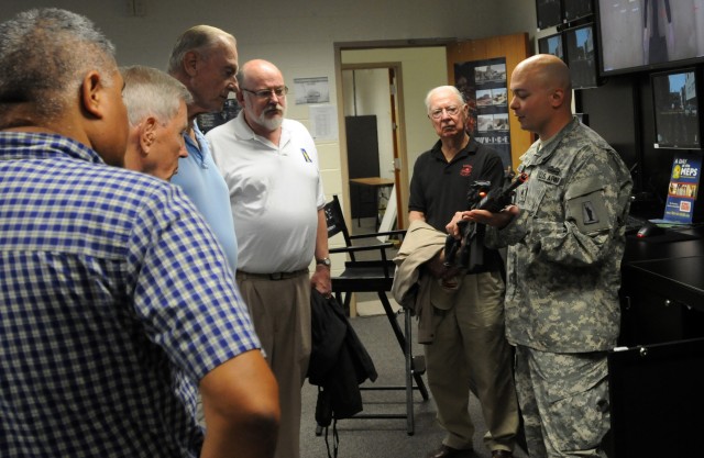 Staff Sgt. Brian Calhoun, 77th Sustainment Brigade, explains the Virtual Interactive Combat Environment to retired Col. Edwin G. Logan, Malcom Schabe, retired Col. Louis H. Sudholz, Jr., retired Col. Ivan Cornielle, and retired Maj. Gen. George Barker during Operation Sustainment Warrior, Aug. 13, 2013, Joint Base McGuire-Dix-Lakehurst. OSW is a training event hosted by the 77th Sustainment Brigade providing a well-planned and resourced training exercise that focuses on maintaining Warrior Skills and enhancing Individual Readiness for targeted soldiers. (U.S. Army photo by Sgt. Peter Jun/Released)