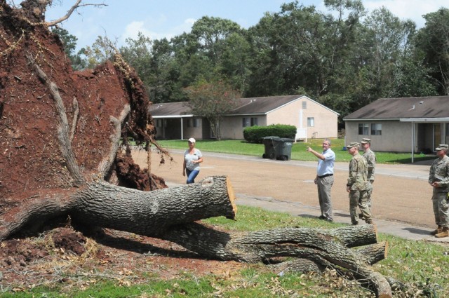 Daniel Bartlett, Corvias Property Management facilities director, points out the next steps in the removal of a large tree stump to Brig. Gen. Patrick D. Frank, Joint Readiness Training Center and Fort Polk commanding general, and the rest of the...