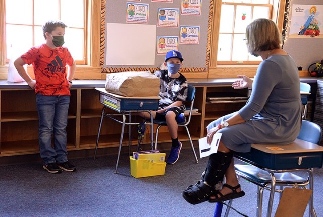 Ten-year-old Luke Tolbert listens to his fifth-grade teacher Joni McCoy explain how students will be able to move around within their six-foot "bubble" during orientation Sept. 3 at Eisenhower Elementary School. Luke's family, including his mom...