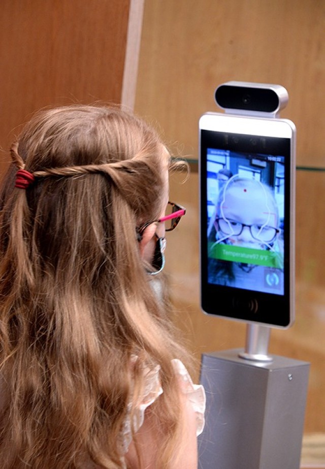 Eight-year-old Ainsley Johnson has her temperature taken as she enters Eisenhower Elementary School to meet her third-grade teacher Sept. 3. Students and their parents met with teachers at the four post schools last week for an orientation about...