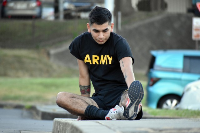 Spc. Max Ramirez, assigned to the 38th Air Defense Artillery Brigade, stretches before training for the Army Ten-Miler at Camp Zama, Japan, Aug. 27.