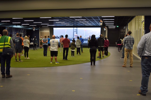 BRUNSSUM, Netherlands – Memorial ceremony attendees at the Brunssum Site watch the Chievres, Belgium ceremony on the big screen at the HUB. At three of its locations in two of its host nations, U.S. Army Garrison Benelux observed the 19th...