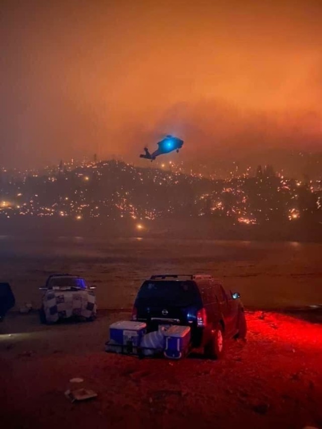 A California Army National Guard UH-60M Black Hawk helicopter from the 40th Combat Aviation Brigade hovers above Mammoth Pool Reservoir before picking up evacuees the night of Sept. 5, 2020.