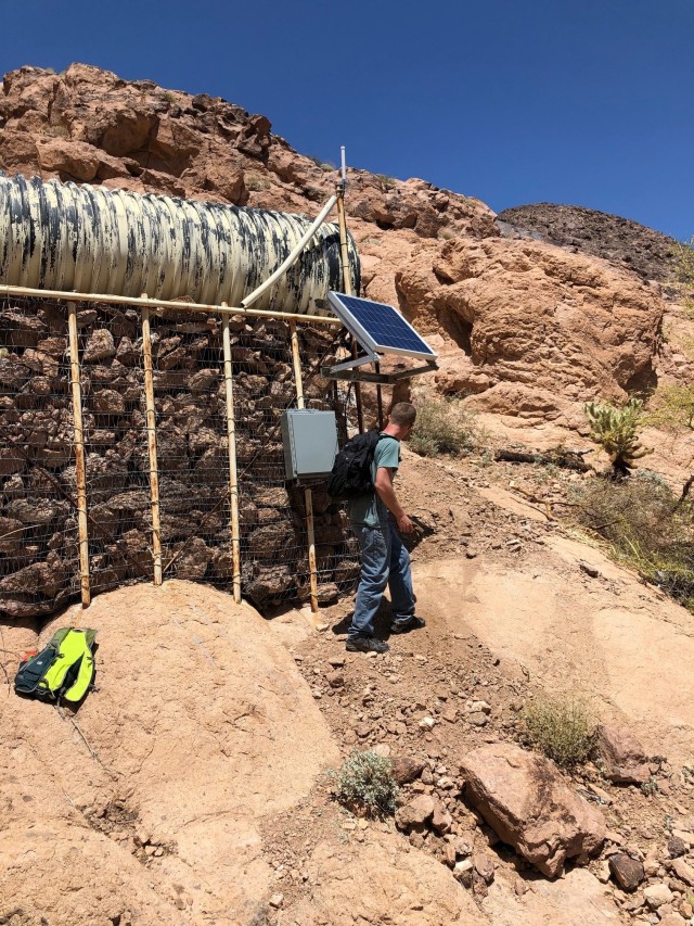 Ryan Ingham and Cory Olsen, Electronics Technicians with the Meteorology Division at YPG, took that pressure senor and installed it in four of the AZDGF wildlife water tanks. Olsen is pictured making his way to the water tank. (Photo by Ryan Ingham)
