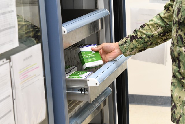 Navy Medicine Readiness and Training Command Sailor opens vaccination refrigerator to examine southern hemisphere flu vaccine at Shipyard Clinic Immunizations Department on September 14, 2020.