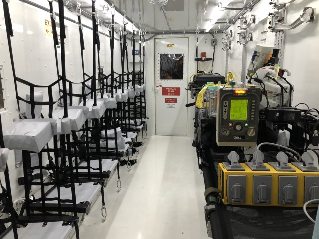 The inside of the NPC-Lite includes ambulatory patient seating (left) and litters with medical equipment (right).