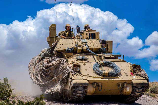 Soldiers from 1st Battalion, 163rd Cavalry Regiment, Montana Army National Guard, push on in their Bradley Fighting Vehicle during a defensive attack training exercise at the National Training Center (NTC) in Fort Irwin, Calif., June 1, 2019.