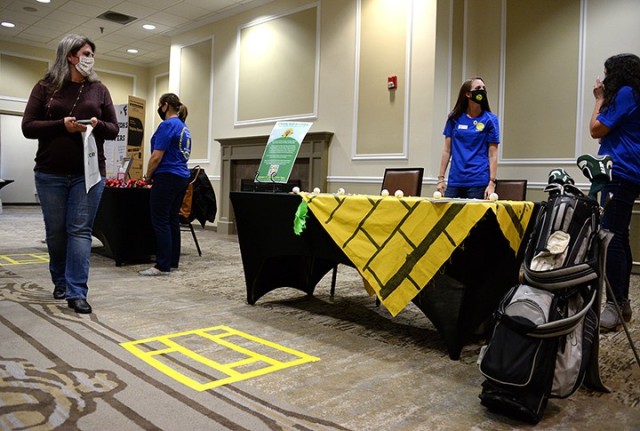 Sara Dunn peruses informational booths as Christi King, Fort Leavenworth Spouses Club first vice president, and Katie Payne, FLSC newsletter chairperson, stand ready to share information about the upcoming charity golf scramble during the FLSC...