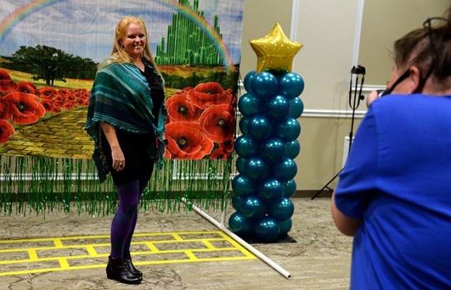 New Fort Leavenworth Spouses Club member Katie Kratz poses with a "yellow brick road" backdrop for photographer Kathy McKinley, FLSC secretary, during the FLSC Super Sign-up Sept. 9 at the Frontier Conference Center. Kratz said she just moved to...