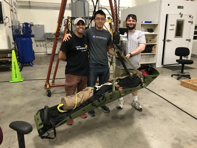 First Lt. Mahdi Al-Husseini, left, an aeromedical evacuations officer, poses for a photo next to his engineering teammates, Anthony Chen and Joshua Barnett, as they show off their Stabilizing Aerial Loads Utility System.