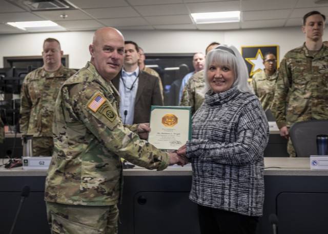 Col. Rodney H. Honeycutt, Chief of Staff, 1st Theater Sustainment Command (TSC), presents a time in service pin and certificate to Ms. Barbara E. Wright for her 15 years of service Feb. 28th, 2020 in Fort Knox, Ky. (U.S. Army Photo by Spc. Zoran Raduka)
