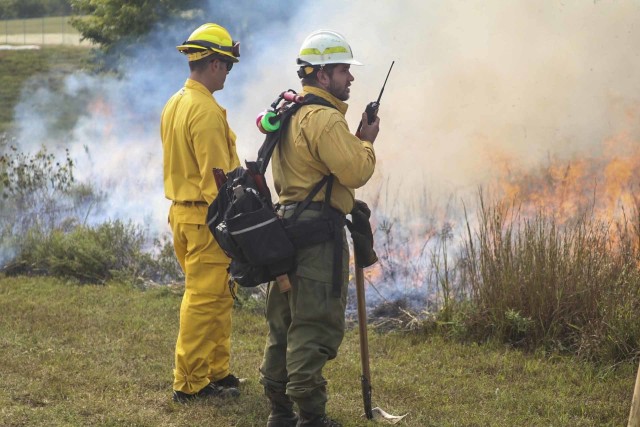 Chris Hanson, District Fire Management Officer with the Kansas Forest Service (right) monitors a controlled burn with a student during the field training day portion of the Wildland Firefighting Red Card Certification Course that took place at the Great Plains Regional Training Center in Salina Sept. 17. The objective of the course, which was made possible through a partnership between the Kansas National Guard and the Kansas Forest Service, was to increase statewide wildland firefighting capabilities by certifying guardsmen across the state to respond to wildfires.