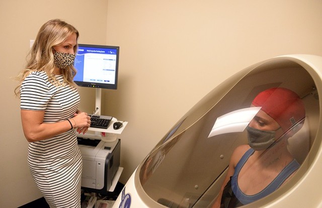 Tessa Brophy, Army Wellness Center director, and Christine Cunningham, AWC health educator, demonstrate use of the Bod Pod to measure the percentage of body fat Sept. 21 at the AWC in Eisenhower Hall. Photo by Prudence Siebert/Fort Leavenworth Lamp