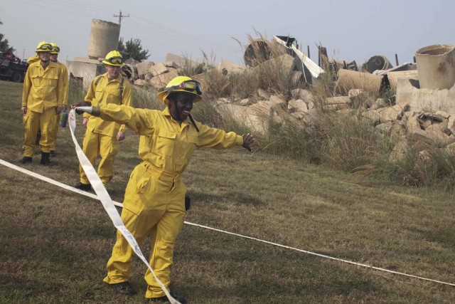 Spc. Michelle Karanu, horizontal construction engineer with the 242nd Engineer Company, 891st Engineer Battalion, from Wichita, Kansas, practices unrolling a segment of hose during the field training day portion of the Wildland Firefighting Red Card Certification Course that took place at the Great Plains Regional Training Center in Salina Sept. 17. The objective of the course, which was made possible through a partnership between the Kansas National Guard and the Kansas Forest Service, was to increase statewide wildland firefighting capabilities by certifying guardsmen across the state to respond to wildfires.