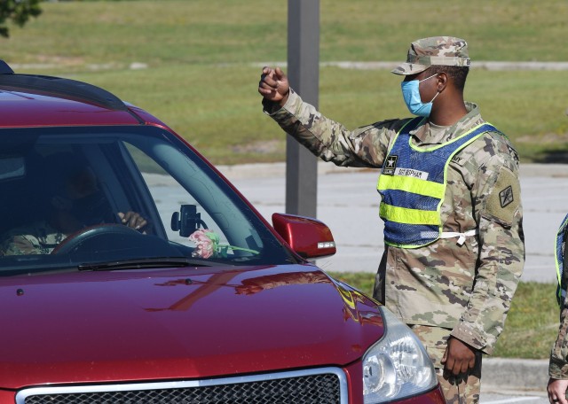 Sgt. Aakif Bispham, with Company B, Headquarters and Headquarters Battalion, answers questions from a motorist during drive thru COVID-19 testing at Fort Jackson Sept. 22.