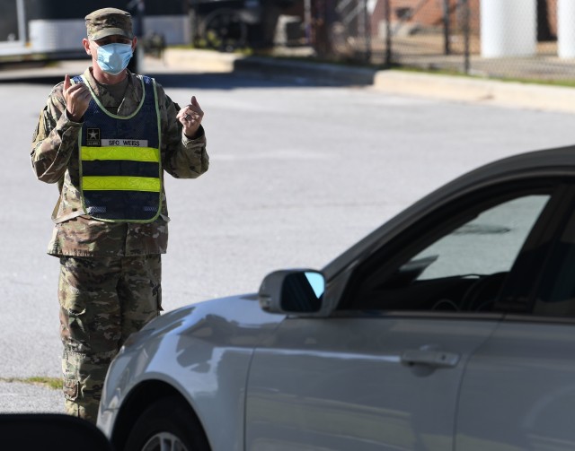 Sgt. 1st Class Kenneth Weiss, with Company B, Headquarters and Headquarters Battalion, guides a vehicle into a testing station during drive thru COVID-19 testing at Fort Jackson Sept. 22.