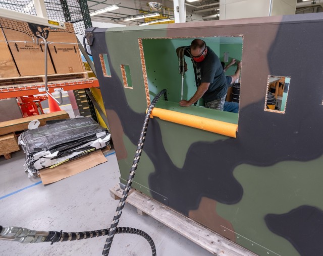 Sheet Metal Mechanics Skylar Milheim, front, and Ed Thomas installs potted inserts on an AN/TPS-80 Ground/Air Task Oriented Radar Communications Equipment Group shelter.