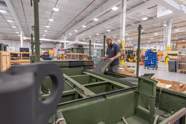 Sheet Metal Worker JJ Johnson installs deck plates on an AN/TPS-80 Ground/Air Task Oriented Radar Power Equipment Group.