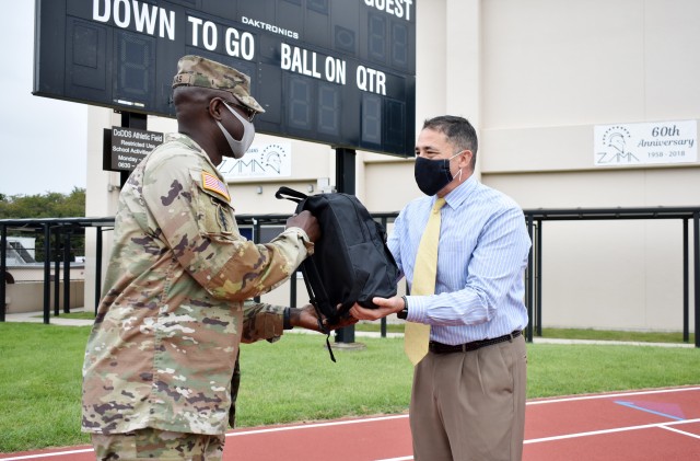 Lt. Col. Demetrick Thomas, left, commander of the 35th Combat Sustainment Support Battalion, hands Henry LeFebre, principal of Zama Middle High School, a backpack full of school supplies at the school, Camp Zama, Japan, Sept. 24. The battalion has...