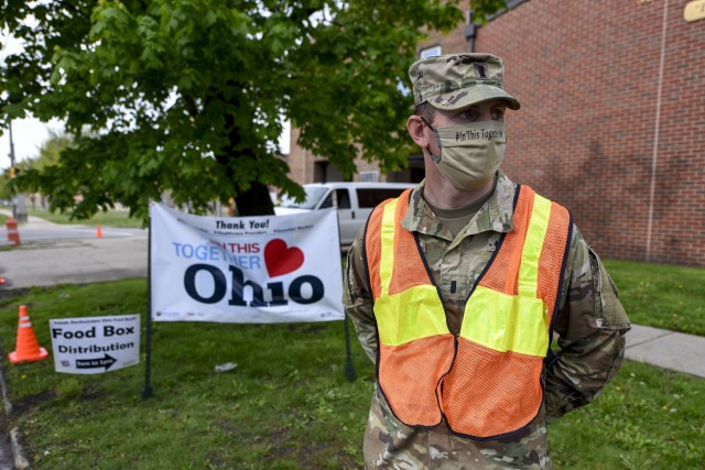 U.S. Army 1st Lt. Michael Porter, a Soldier assigned to the Ohio National Guard’s HHC 1-148th Infantry Regiment – 37th Infantry Brigade Combat team, waits for vehicles during a drive-through food distribution event at the James Caldwell Center...