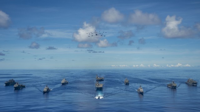 200925-N-KP021-0628 PHILIPPINE SEA (Sept. 25, 2020) From left, USNS Charles Drew (T-AKE 10), USS Comstock (LSD 45), USS Shiloh (CG 67), USS New Orleans (LPD 18), USS Chicago (SSN 721), USS America (LHA 6), USS Ronald Reagan (CVN 76), USNS John Ericsson (T-AO 194), USS Antietam (CG 54), USS Germantown (LSD 42), and USNS Sacagawea (T-AKE 2) steam in formation while E/A-18G Growlers and FA-18E Super Hornets from Carrier Air Wing (CVW) 5, a P-8 Poseidon from Commander Task Force 72, and U.S. Air Force F-22 Raptors and a B-1B Bomber fly over the formation in support of Valiant Shield 2020. Valiant Shield is a U.S. only, biennial field training exercise (FTX) with a focus on integration of joint training in a blue-water environment among U.S. forces. This training enables real-world proficiency in sustaining joint forces through detecting, locating, tracking and engaging units at sea, in the air, on land and in cyberspace in response to a range of mission areas. (U.S. Navy photo by Mass Communication Specialist 2nd Class Codie L. Soule)